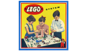 Children building a LEGO town using the early LEGO System, highlighting creative play with simple bricks and structures.