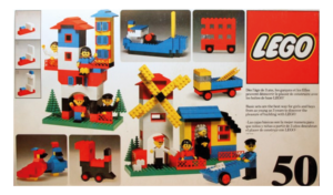 Vintage LEGO set packaging showing simple houses, vehicles, and a windmill built from early LEGO bricks.